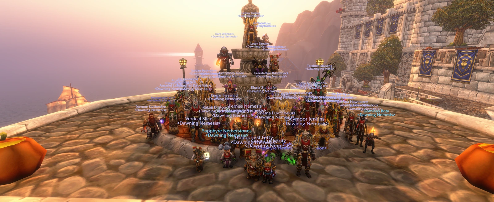 Dawning Nemesis members gathered around a stone monument above Stormwind Harbor at sunset.